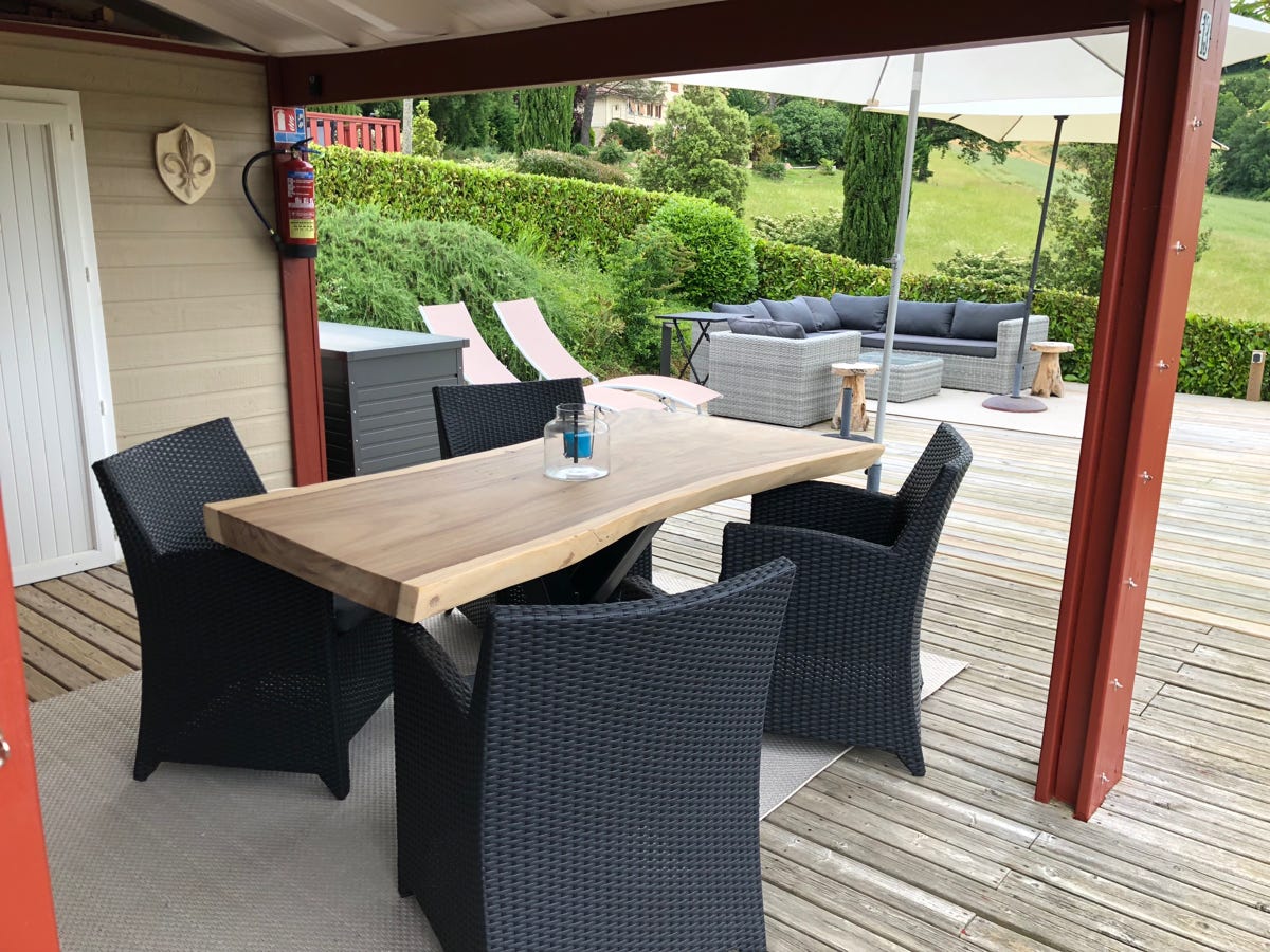 Boomstam tafel onder overdekt terras bij Chalet 13 / PRL 13 bij Camping Le Talouch in de Gers, zuid Frankrijk